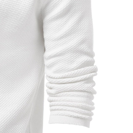 Close-up of a white textured merino knit sweater with a C-neckline and ruched sleeves, showcasing fabric detail and craftsmanship.