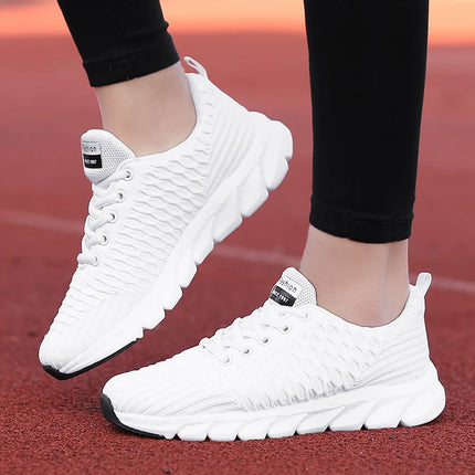 Lightweight and breathable women's white athletic shoes on a track, perfect for comfortable running and exercise.