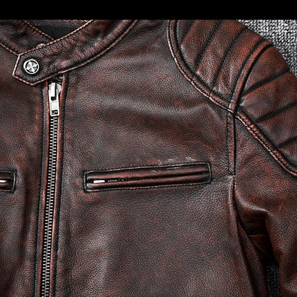 Close-up of a brown leather jacket made from 100% cowhide, featuring zippered pockets and quilted shoulder details.