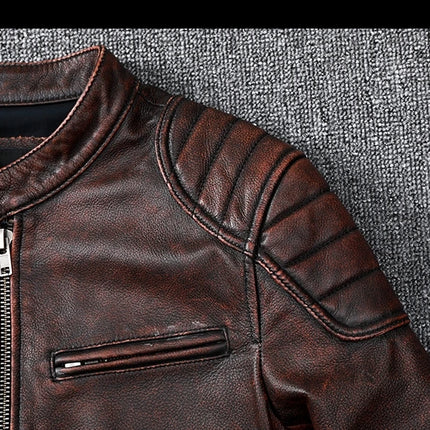 Close-up of brown genuine cowhide leather jacket with zipper and detailed stitching on textured fabric background.
