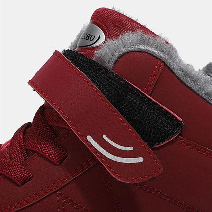 Close-up of warm, waterproof, anti-slip red snow boots featuring a secure velcro strap and plush lining.