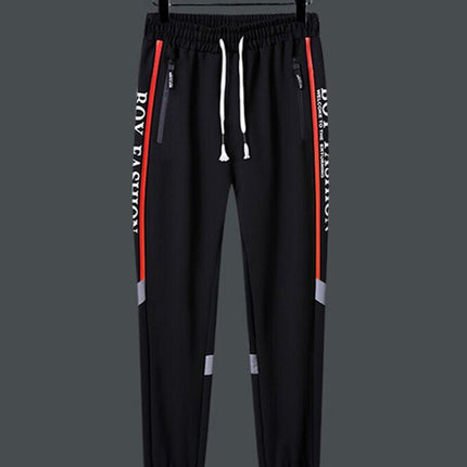 Pantalón deportivo negro con cintura elástica y detalles gráficos rojos, ideal para estilo urbano y entrenamiento. Talle disponible: P a GG.
