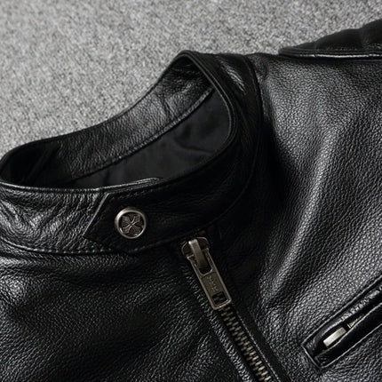 Black leather jacket made from 100% cowhide, featuring a sleek zipper and stylish design on a grey background.