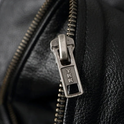 Close-up of a YKK zipper on a 100% genuine cowhide leather jacket, emphasizing luxury and quality craftsmanship.