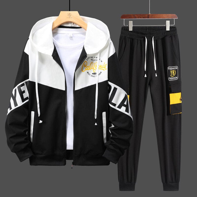 Urban style men's tracksuit with black and white hoodie, graphic details, and elastic waist pants with yellow accents.