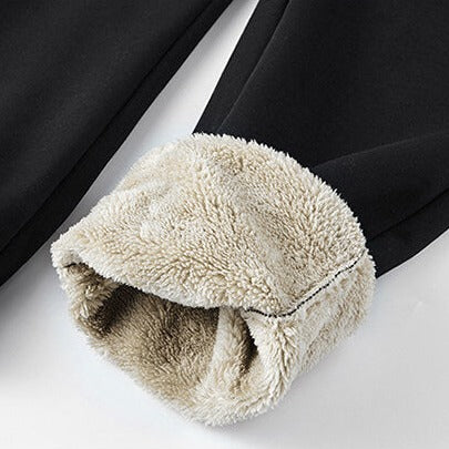 Detalle de puño forrado en sherpa de conjunto de buzo y pantalón para hombre, color negro, ideal para el invierno.