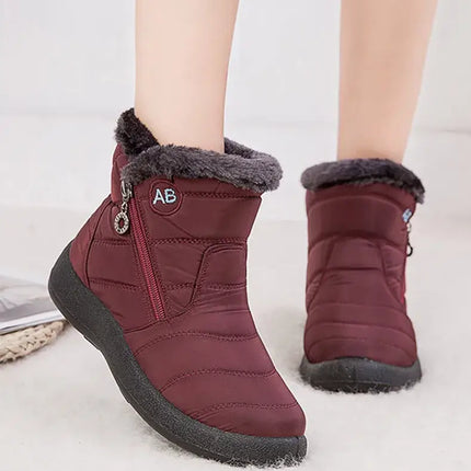 Bota impermeable burdeos de mujer, con abrigo interior de felpa y diseño elegante, ideal para el invierno. Tacón bajo y punta redonda.