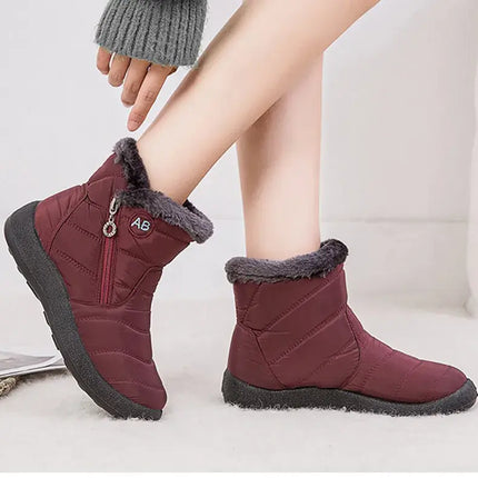 Botas impermeables de mujer color burdeos con forro interior de felpa, ideales para invierno y diseño moderno.