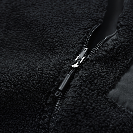 Cierre de la campera Expedition en lana negra, destacando textura suave y funcionalidad ideal para actividades al aire libre. Campera Hombre.