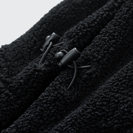 Primer plano del acabado en lana de la Campera Hombre Expedition en color negro, destacando su textura suave y capucha ajustable.