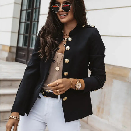 Mujer usando una Campera Gabriela negra para mujer, con botones dorados y gafas de sol, exterior de edificio.