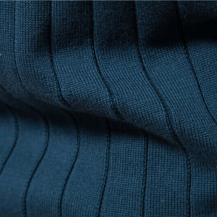 Textura de tejido de punto azul fino de Campera Hombre, mezclada con algodón y acrílico, destacando suavidad y patrón geométrico en relieve.