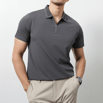 Hombre vistiendo Chomba Everett gris, ideal para días calurosos, combinada con pantalón chino beige. Moda minimalista de alta performance.