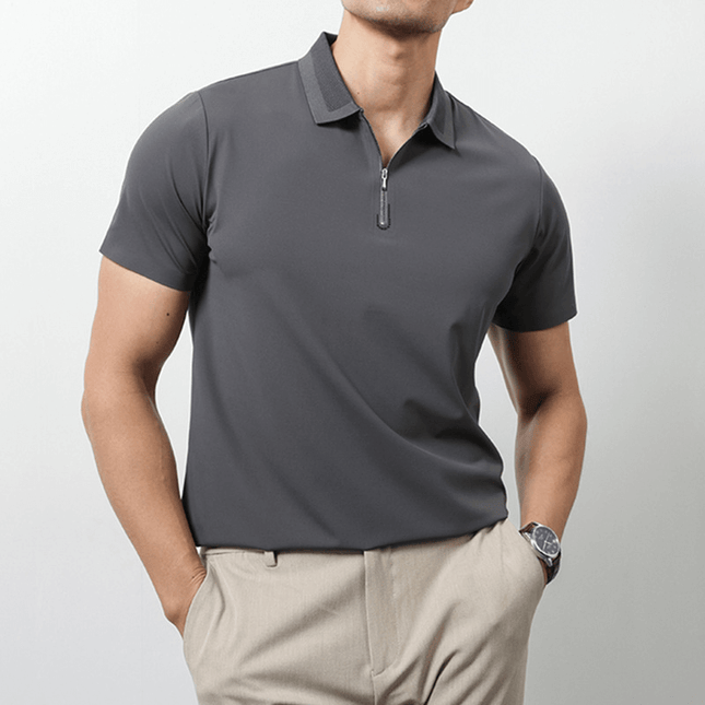 Hombre vistiendo Chomba Everett gris, ideal para días calurosos, combinada con pantalón chino beige. Moda minimalista de alta performance.