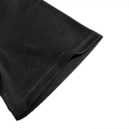 Detalle de la manga de una chomba de algodón peinado en color negro, vista de cerca mostrando la costura precisa y acabado de alta calidad.