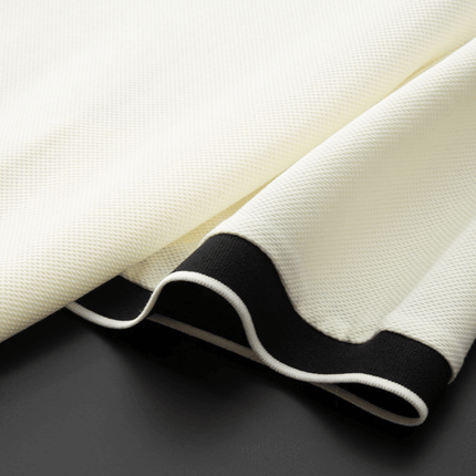 Textura de la Chomba Odyssey para hombre con detalle de borde contrastante en blanco y negro, ideal para estilo y comodidad diaria.