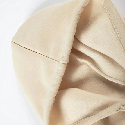 Close-up of the hood from a beige men's hoodie, showing thick fabric and plush lining for warmth.