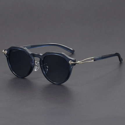 Gafas de sol hombre vintage estilo Bob Dylan con lentes degradé oscuros, forma redonda geométrica y detalles metálicos.