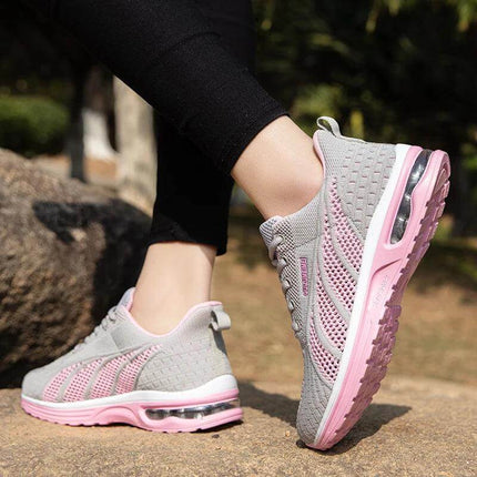 Nueva zapatilla deportiva transpirable gris con detalles rosados, suela antiimpacto y diseño ergonómico para comodidad y soporte óptimo.