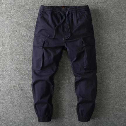 Pantalón militar camuflado para hombre, color oscuro, diseño ajustado con múltiples bolsillos para estilo y funcionalidad.