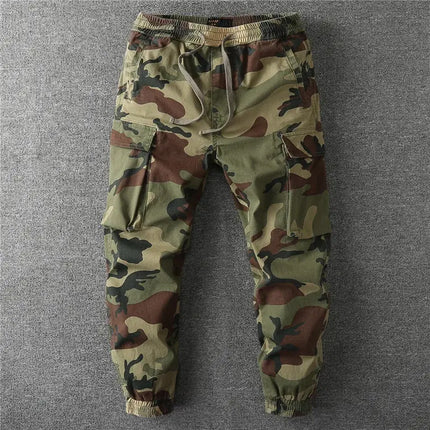 Pantalón militar camuflado para hombre, ideal para actividades al aire libre, con bolsillos grandes y diseño moderno en tonos verdes.