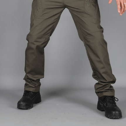 Hombre luciendo pantalones cargo tácticos de color oscuro, ideales para comodidad y resistencia, con múltiples bolsillos para uso diario.