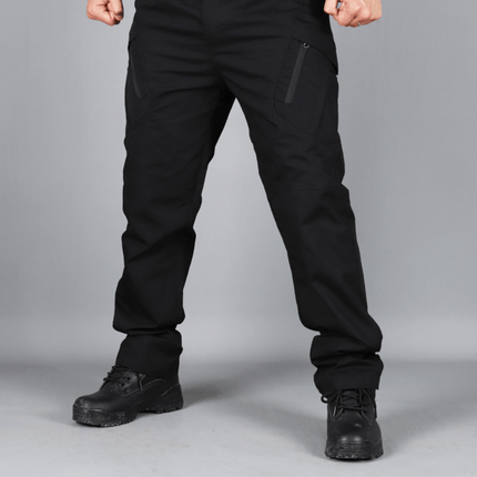 Hombre vistiendo pantalones cargo tácticos negros, mostrando su resistencia y múltiples bolsillos para uso urbano y trabajo.