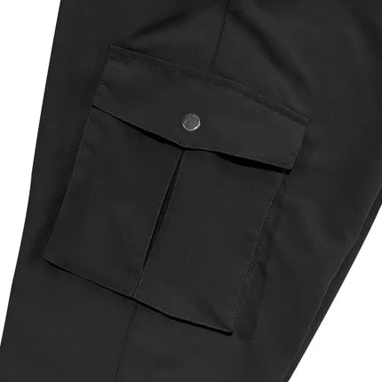 Close-up of a black versatile sports pants pocket with button closure.