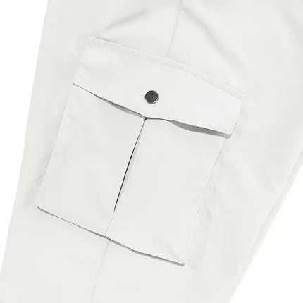 Close-up of versatile sports pants pocket with button closure in white fabric.