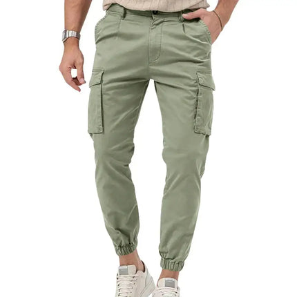 Hombre vistiendo pantalones deportivos versátiles verdes con bolsillos laterales y tobillo ajustado, ideal para actividades casuales.