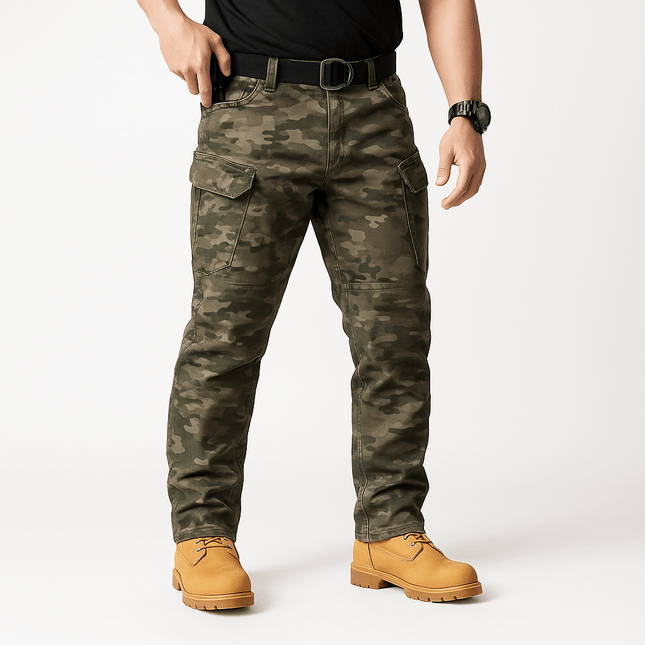 Hombre vistiendo pantalones tácticos impermeables camuflados, múltiples bolsillos, ideales para actividades al aire libre.