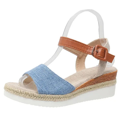Elegant women's fine-style sandal with blue strap and brown buckle, featuring a comfortable wedge heel for summer events.