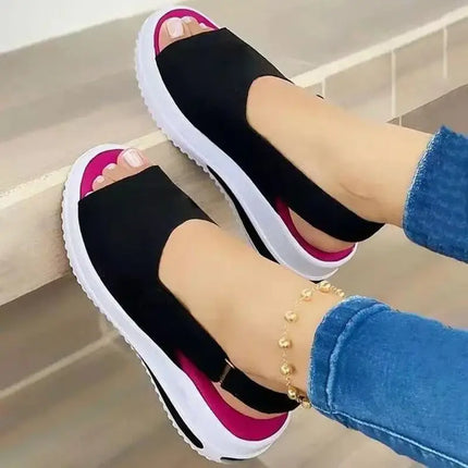 Woman wearing Sandalia Liviana Plus, open-toe black sandals with a lightweight platform, showcasing modern design and comfort.