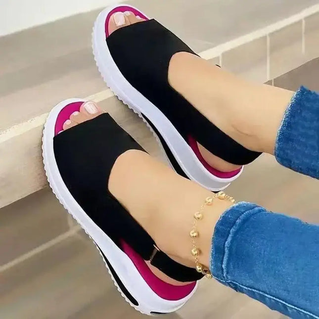 Woman wearing Sandalia Liviana Plus, open-toe black sandals with a lightweight platform, showcasing modern design and comfort.