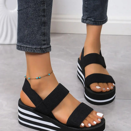 Woman wearing Sandalia Suela Soft with thick platform, open toe, and back strap for comfort and style on warm days.
