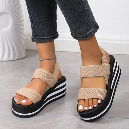 Woman wearing Sandalia Suela Soft, beige platform sandals with open toe and backstrap, ideal for summer style and comfort.