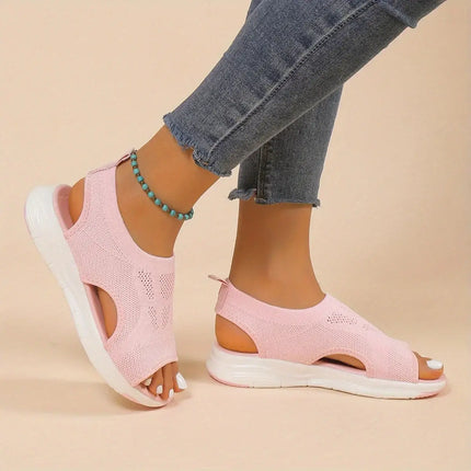 Woman wearing Sandalia Verano Fit pink open-toe sandals with adjustable back strap and light wedge heel, perfect for summer comfort.