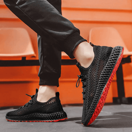 Hombre usando zapatillas deportivas Impacto Pulse de malla negra, con suela antideslizante roja y diseño ligero.