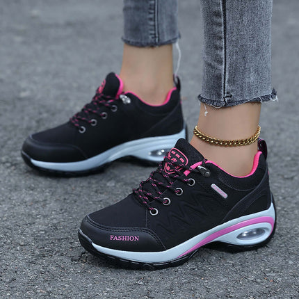 Black and pink ComfortWalk Outdoor sneakers with breathable leather and shock-proof soles on a concrete surface.