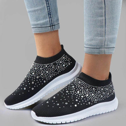 Mujer usando zapatillas confort glitter negras con jeans, diseño ergonómico para soporte óptimo y estilo urbano elegante.