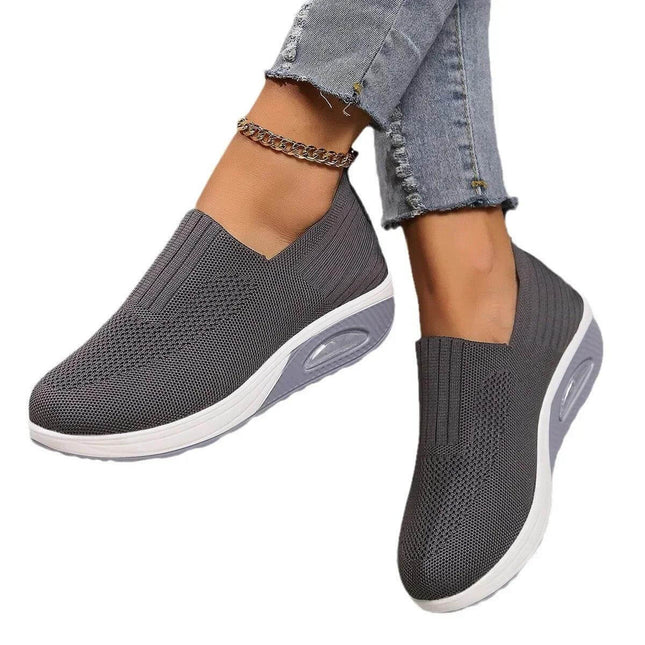 Zapatillas Confortplus in gray worn with jeans, showcasing comfort-focused design with high-quality materials for irritation-free wear.