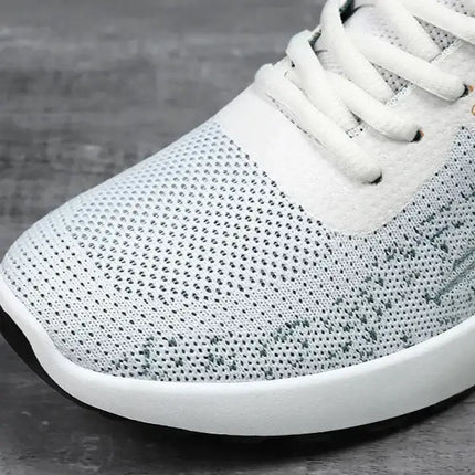 Zapatillas deportivas hombre en malla blanca, diseño moderno y liviano, perfectas para comodidad diaria.