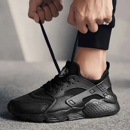 Hombre ajustando zapatillas deportivas Street Air negras, ligeras y versátiles, ideales para uso urbano y deportivo.