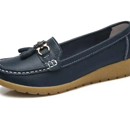 Elegante zapatilla tipo mocasín para mujer en color azul con detalle metálico, ideal para un look minimalista y cómodo.