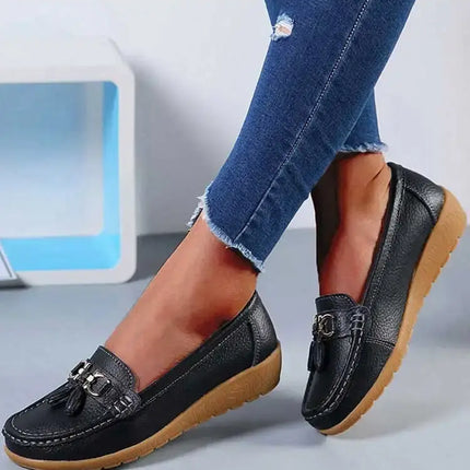 Zapatillas Mujer tipo mocasín en negro, elegantes y cómodas, con detalle metálico y suela flexible, perfectas para un look diario.