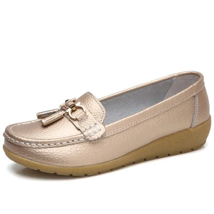 Elegante zapatilla tipo mocasín para mujer en color beige-oro con detalle metálico, ideal para comodidad y estilo diario.