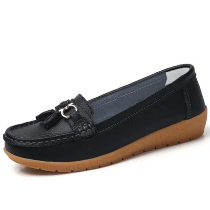 Zapatillas mujer tipo mocasín negras con acabado sintético cuero y detalle metálico, ideales para confort y elegancia diaria.