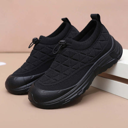 Zapato SoftWalk Urban: Black breathable sneakers on display, featuring stylish quilted design and durable sole for comfortable wear.