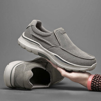 Zapatos de lona sin cordones grises para hombre, con suela antideslizante y diseño casual, vistos desde el lado y de pie.